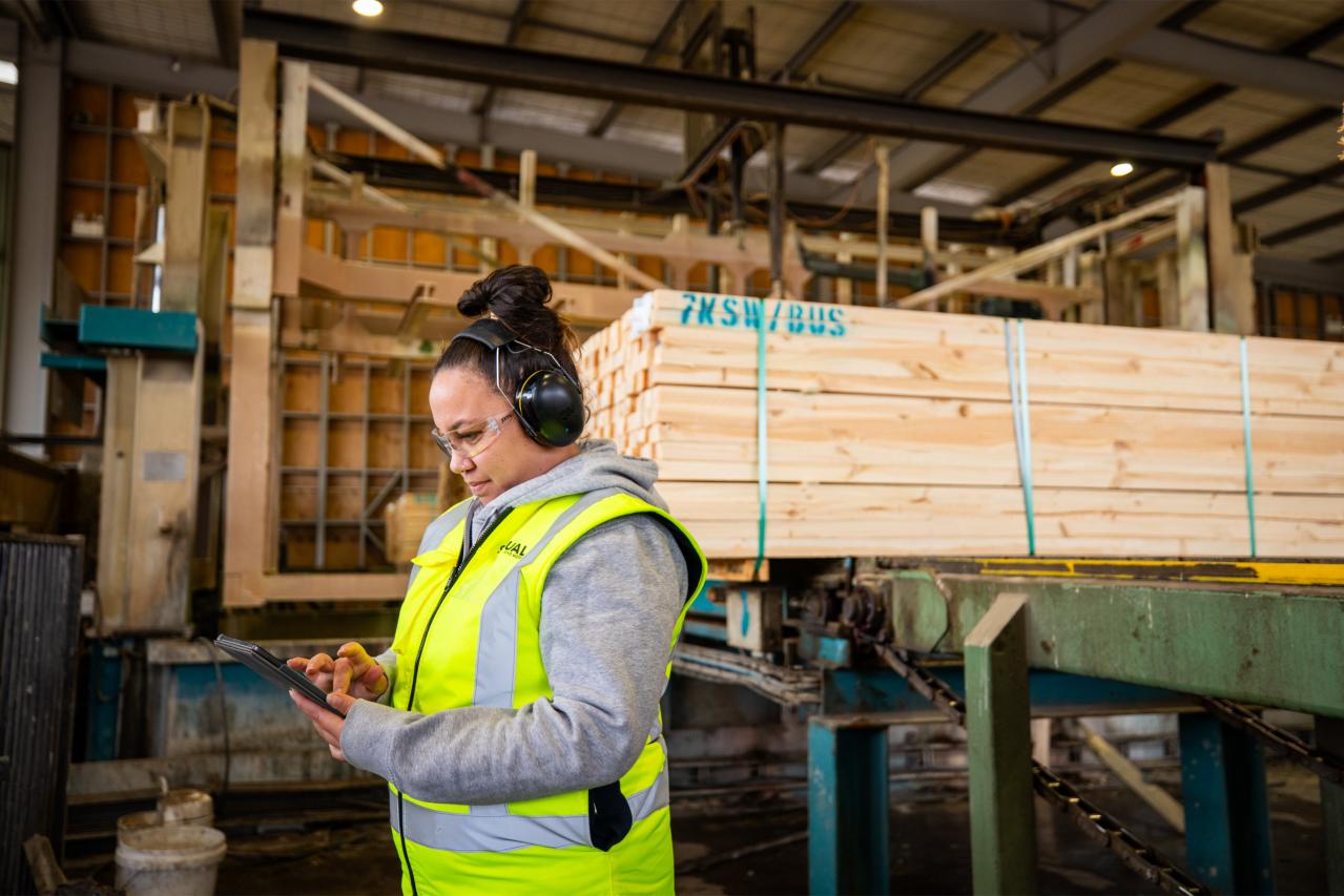 Women standing by timber with high vis