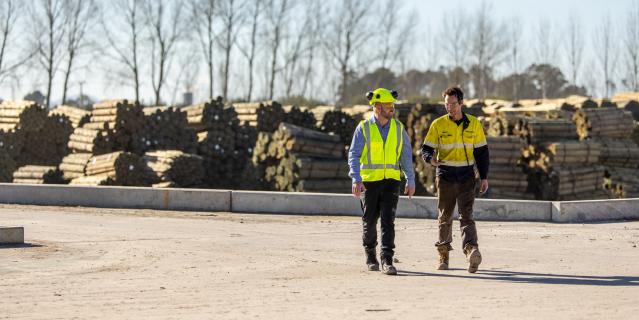 Staff walking in the yard wearing hi-viz and safety equipment